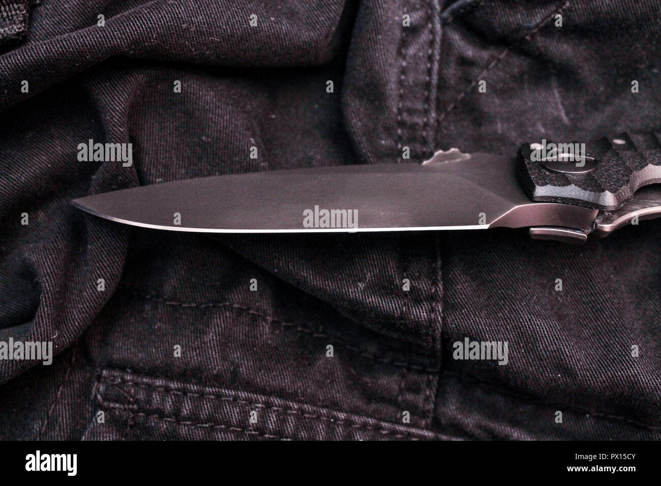 The edge of a military knife. The cutting part of the knife. Black