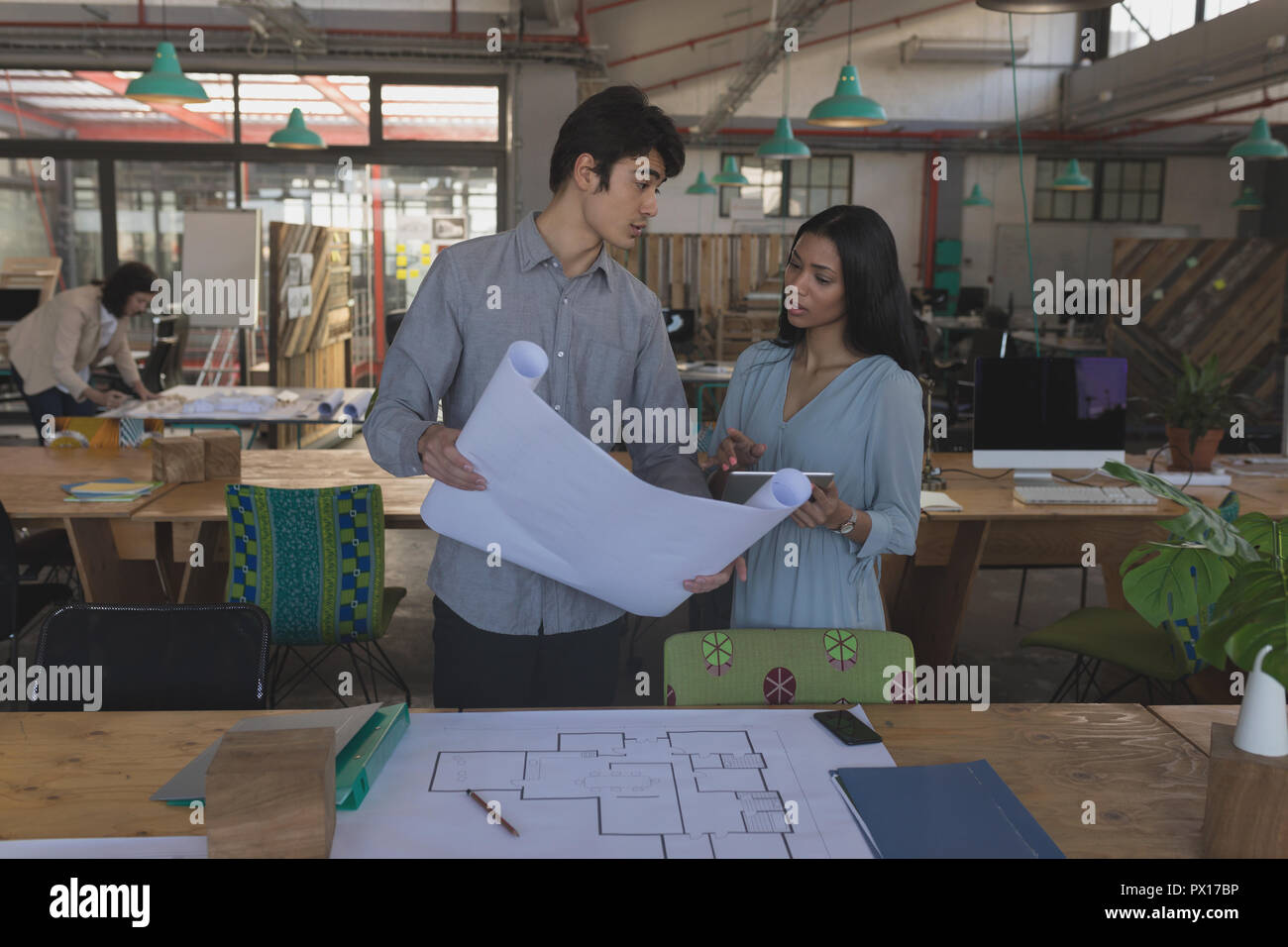 Executives discussing over blueprint Stock Photo