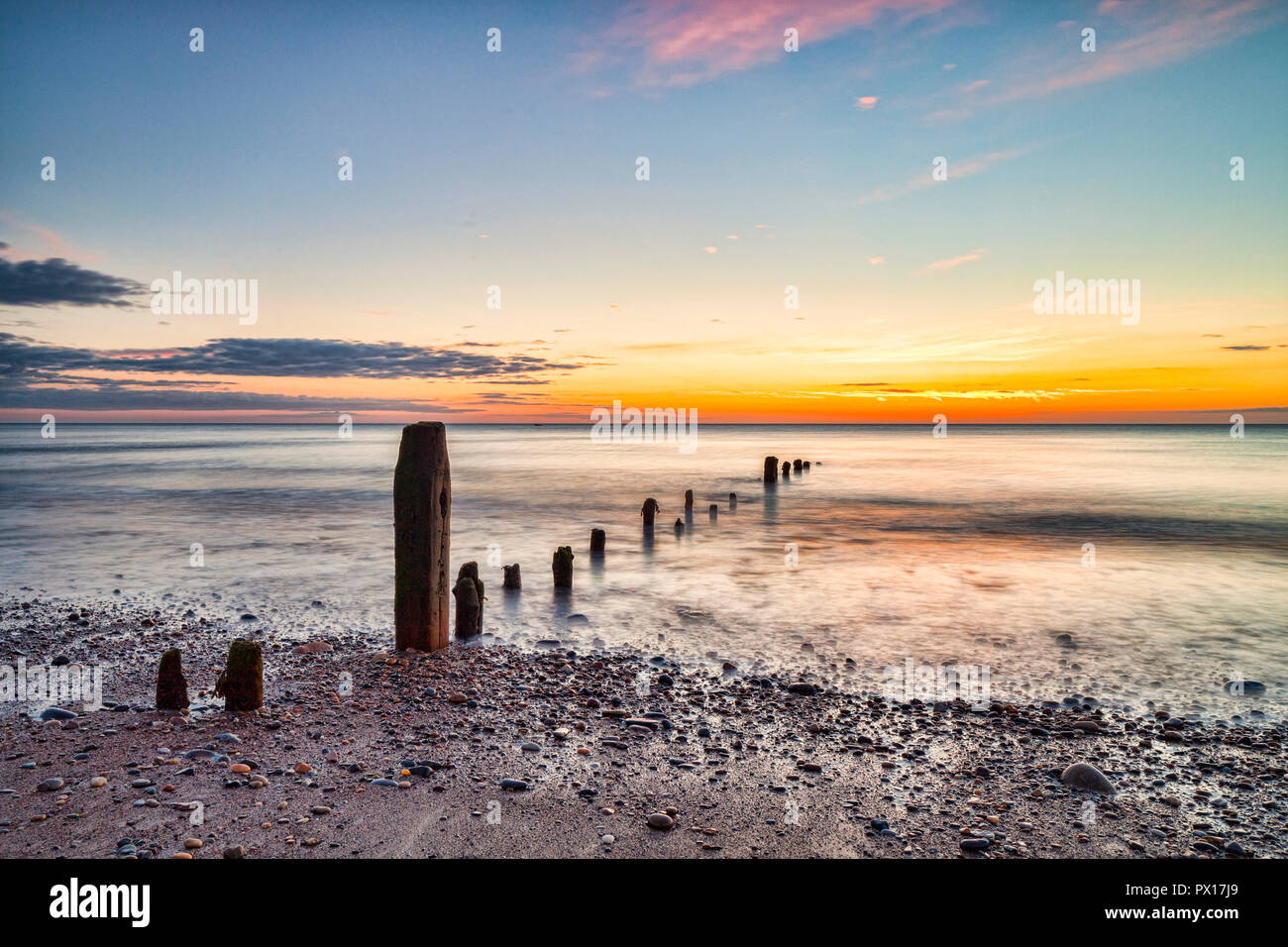 Remains of groynes on the beach at Sandsend, Whitby, North Yorkshire, at dawn Stock Photo