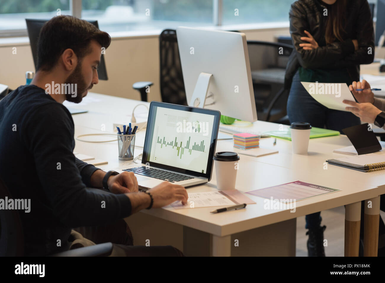 Businessman reviewing the sales graph on laptop Stock Photo