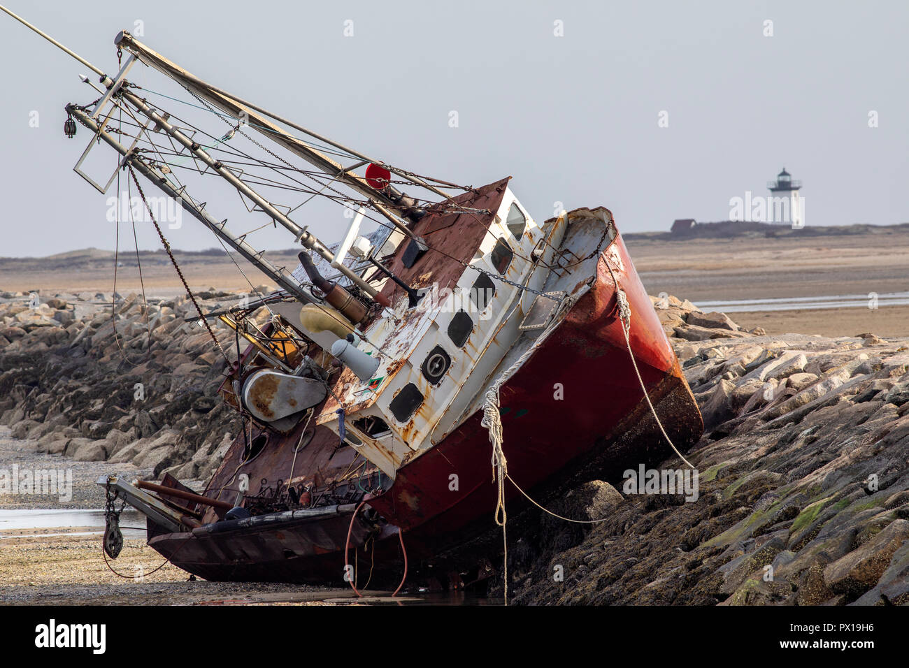 An abandoned derelict fishing boat stranded on a rock jetty Stock Photo ...