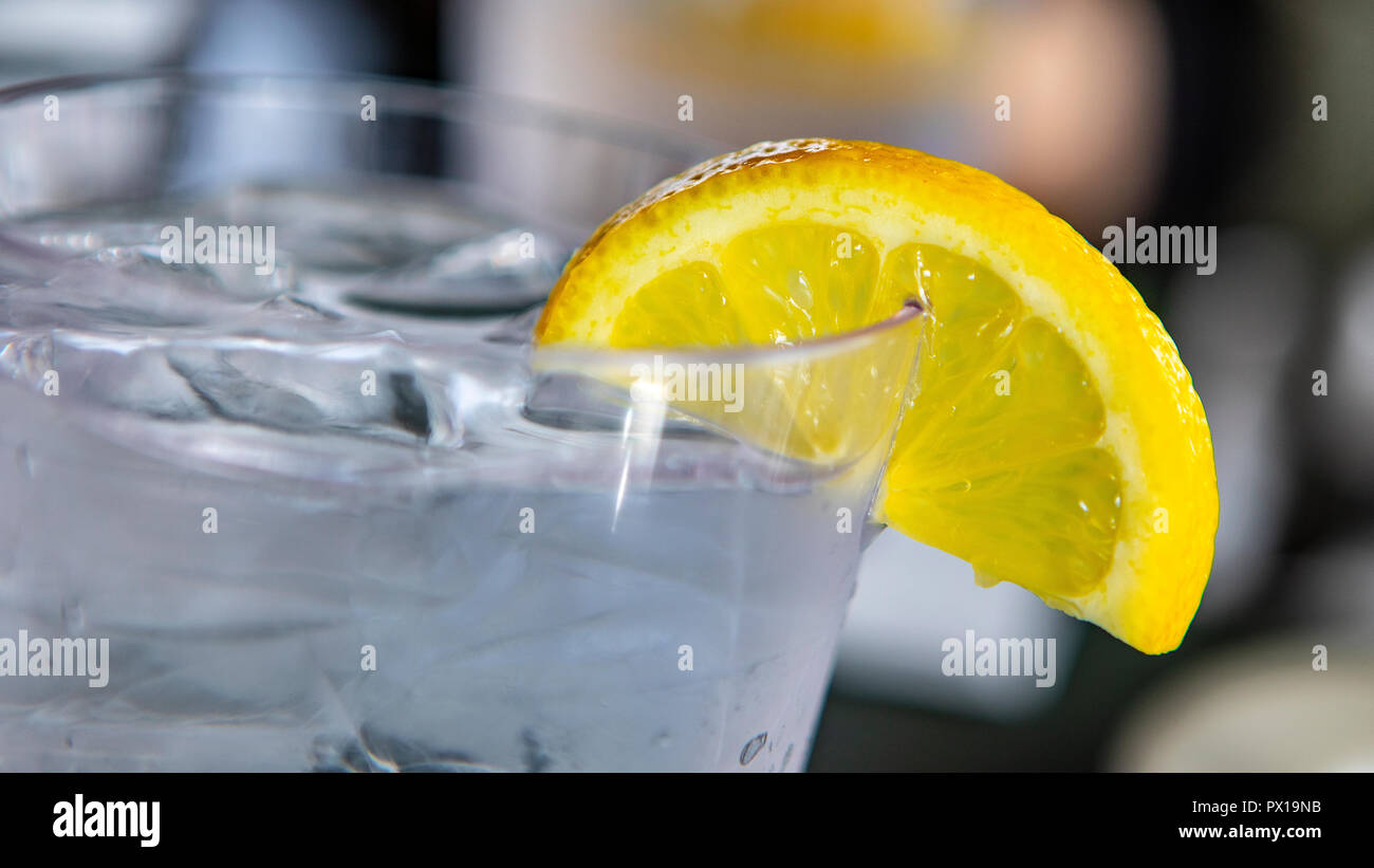 A refreshing glass of water with a lemon wedge to drink. Stock Photo