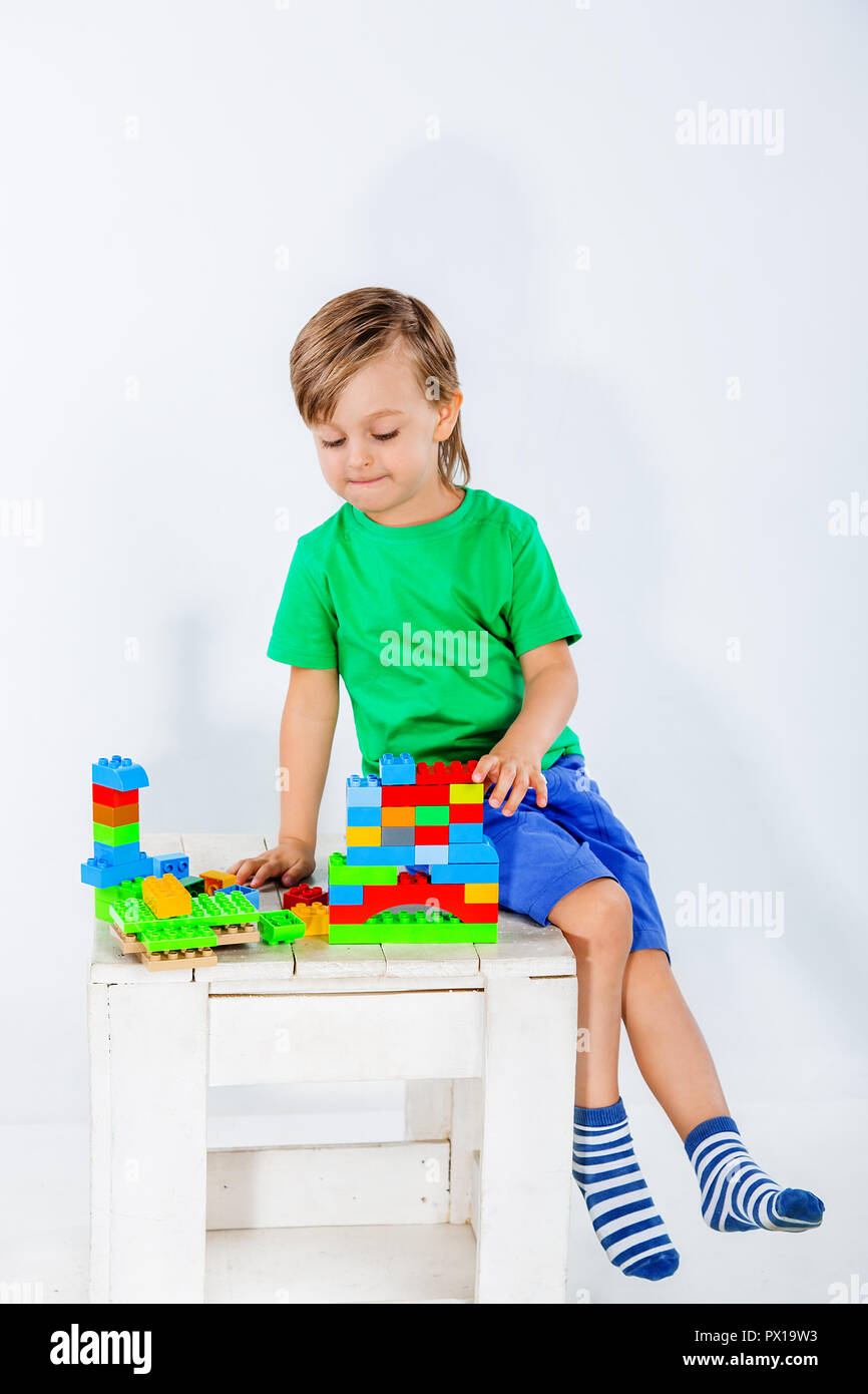 Little boy playing with lots of colorful plastic blocks constructor ...