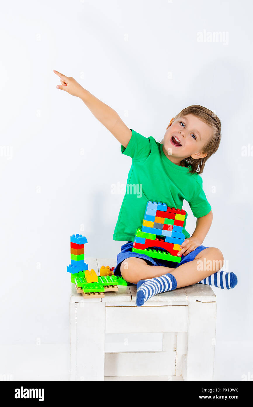 Little boy playing with lots of colorful plastic blocks constructor ...