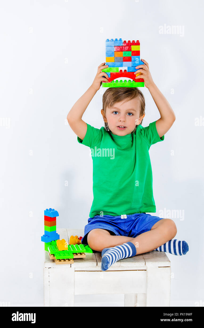 Little boy playing with lots of colorful plastic blocks constructor ...