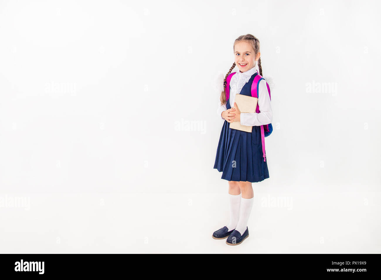 Cute schoolgirl with notebooks and books on a white background ...