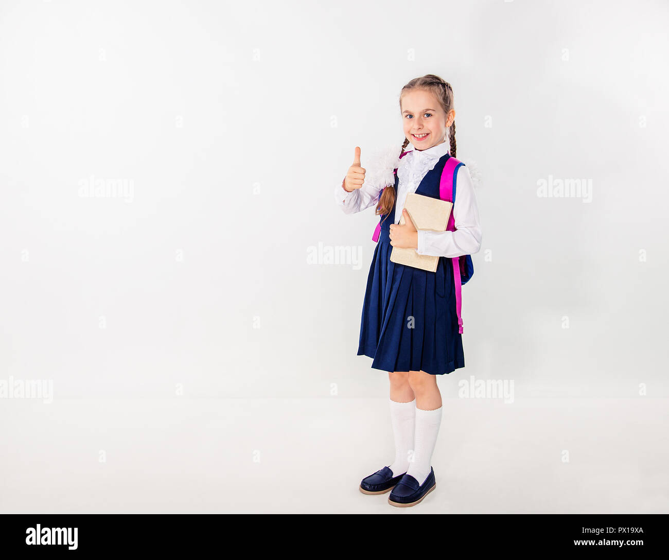 Cute schoolgirl with notebooks and books on a white background ...