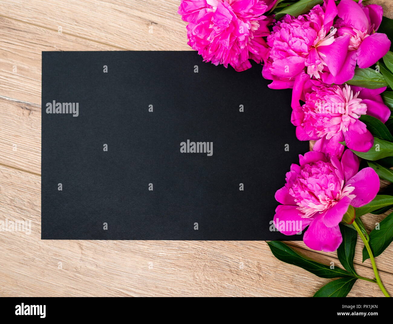 Pink floral assorted pink flower on wooden background with black paper Stock Photo