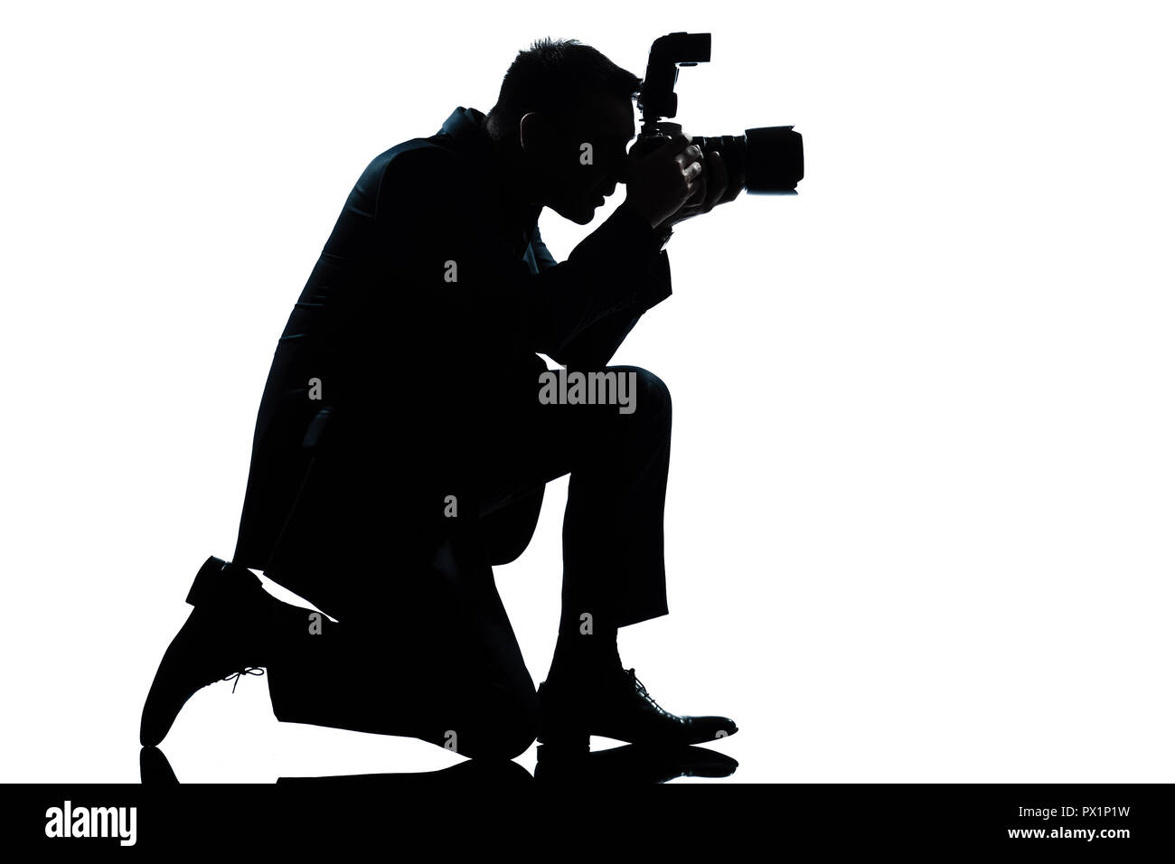 one caucasian man kneeling photographer full length silhouette in studio isolated on white background Stock Photo