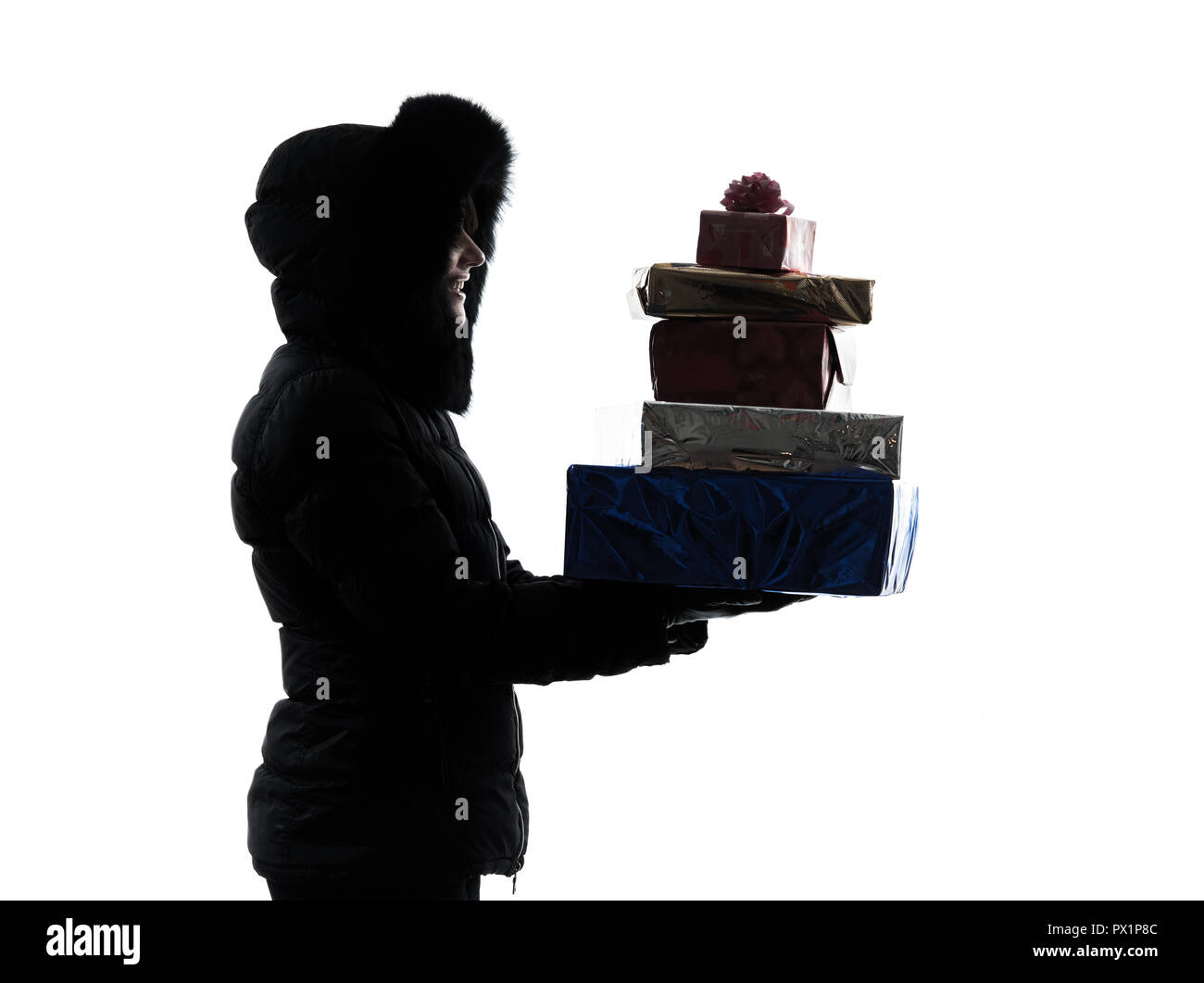 one woman in winter coat carrying christmas gifts silhouette on white background Stock Photo