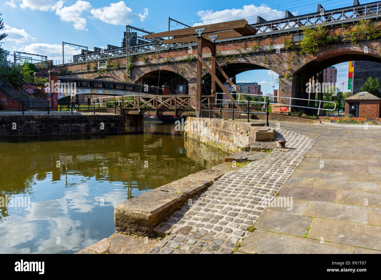 A Victorian railway viaduct and a modern footbridge at Slate Wharf on the Bridgewater Canal at Castlefield, Manchester, England, UK Stock Photo