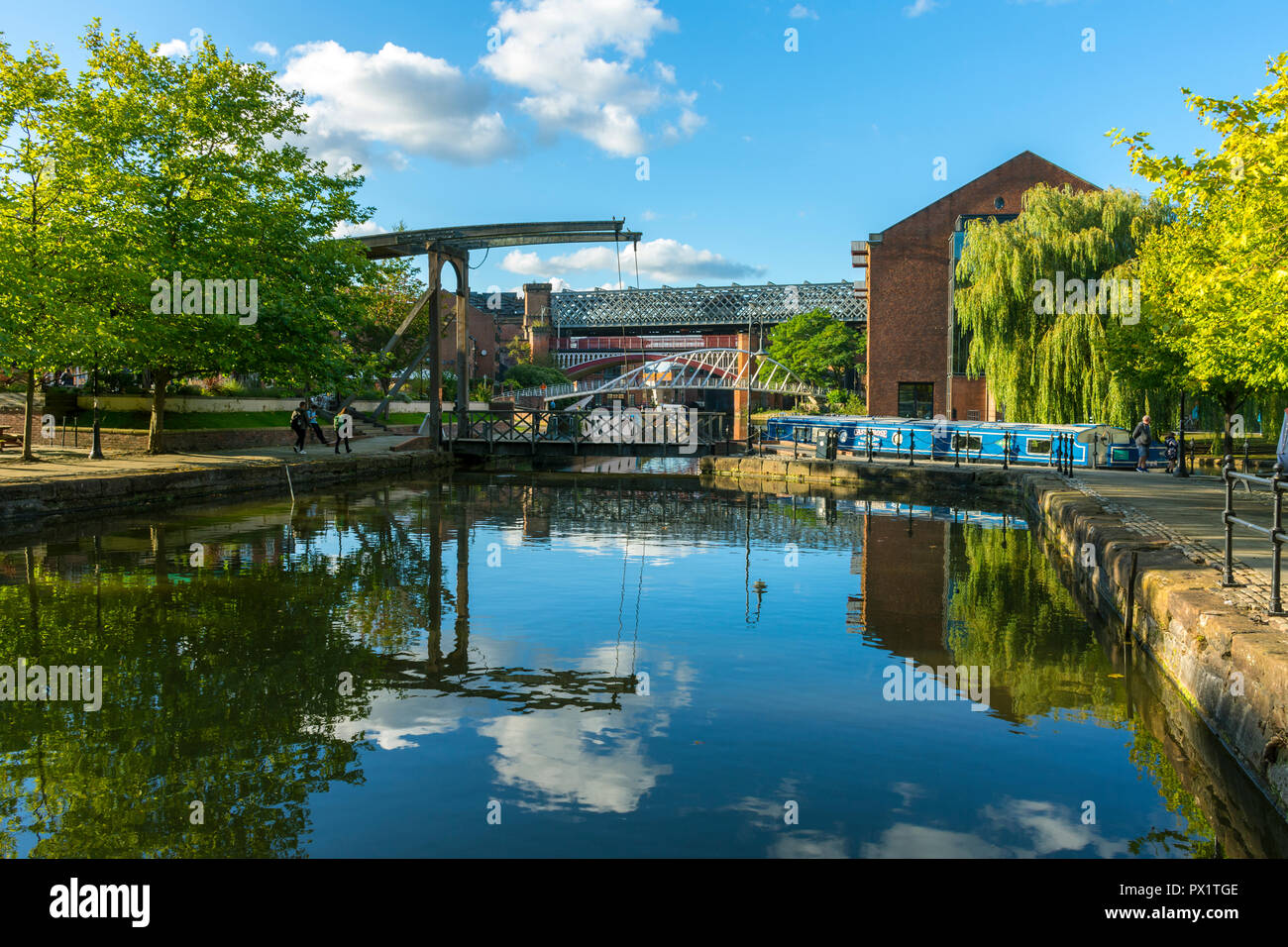 A bascule footbridge, the Merchants' Bridge and Victorian railway viaducts from the Middle Warehouse basin, Castlefield, Manchester, England, UK Stock Photo