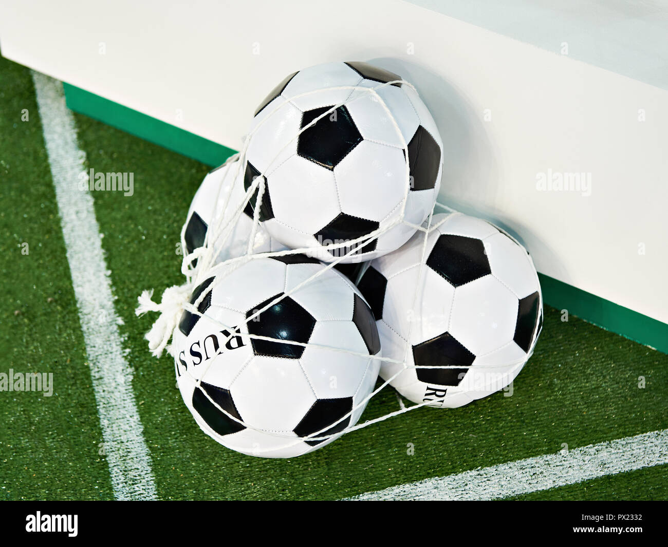 Classic soccer balls in a grid on a green football field lawn Stock Photo