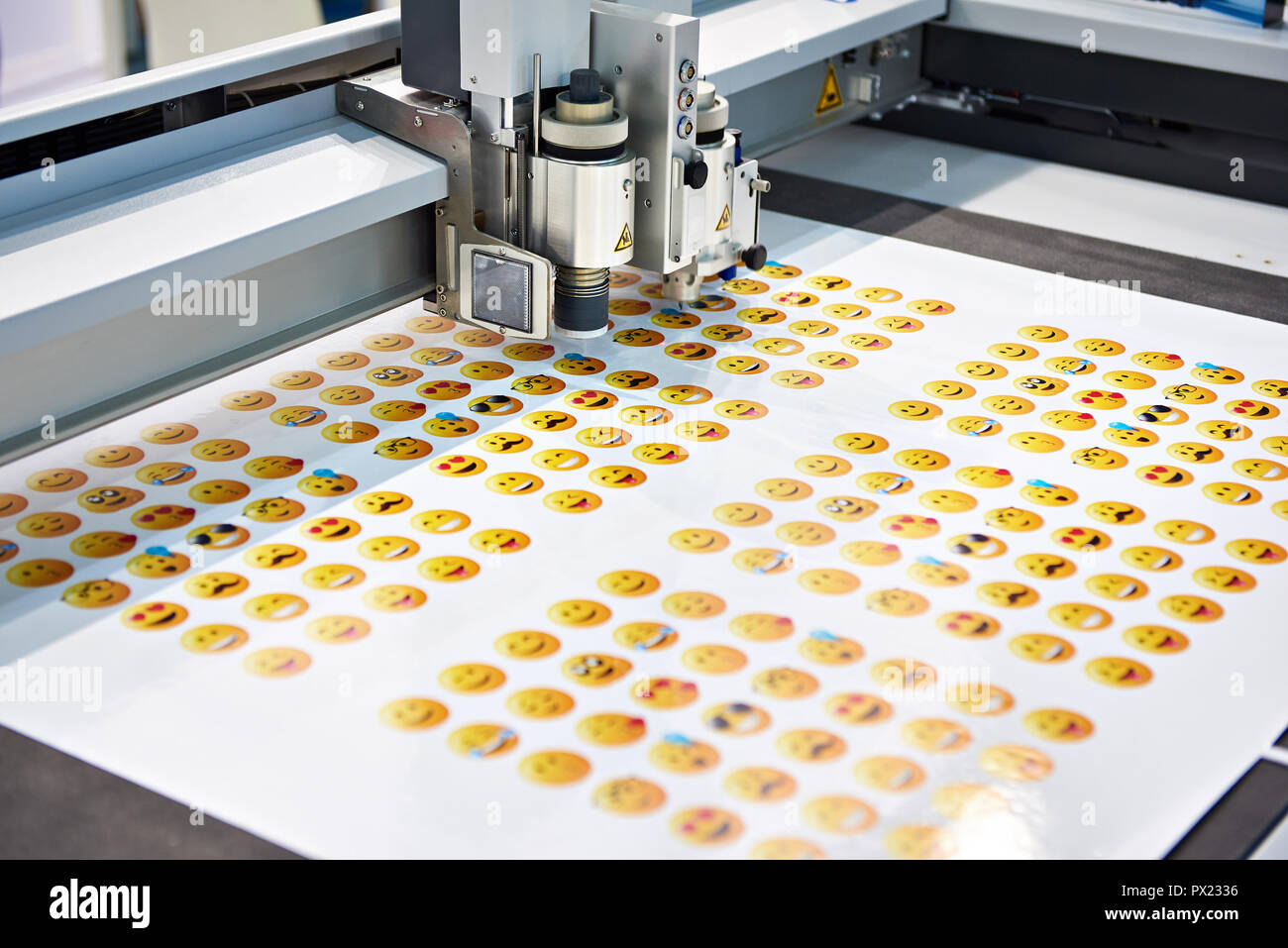 Working digital cutting plotter and yellow smileys Stock Photo