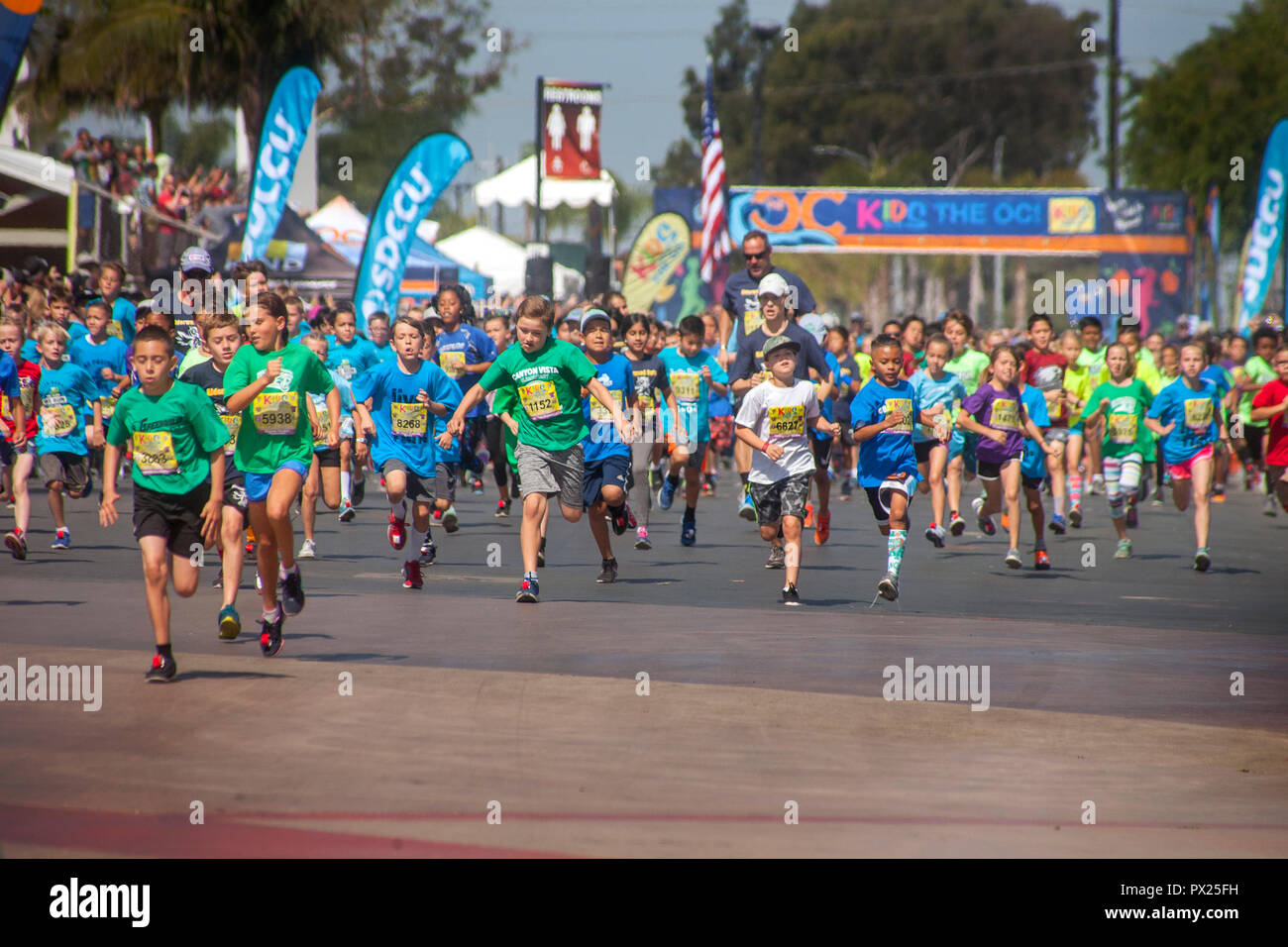 10-year-old multiracial runners leave the starting line as the race begins at a community track event in Costa Mesa, CA. Stock Photo