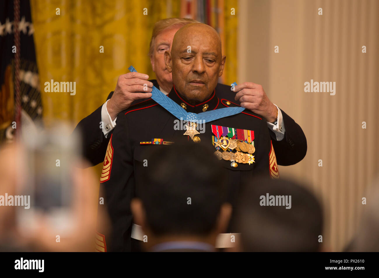President of the United States Donald J. Trump places the Medal of Honor around retired U.S. Marine Corps Sgt. Maj. John L. Canley's neck, the 300th Marine Medal of Honor recipient, at the White House in Washington, D.C., Oct. 17, 2018. From Jan. 31, to Feb. 6 1968 in the Republic of Vietnam, Canley, the company gunnery sergeant assigned to Alpha Company, 1st Battalion, 1st Marines, took command of the company, led multiple attacks against enemy-fortified positions, rushed across fire-swept terrain despite his own wounds and carried wounded Marines into Hue City, including his commanding offic Stock Photo