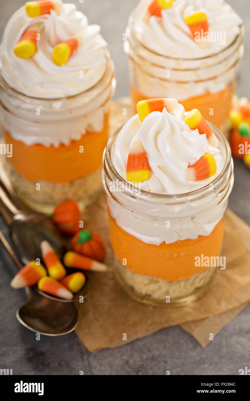Layered candy corn dessert in jars for Halloween Stock Photo