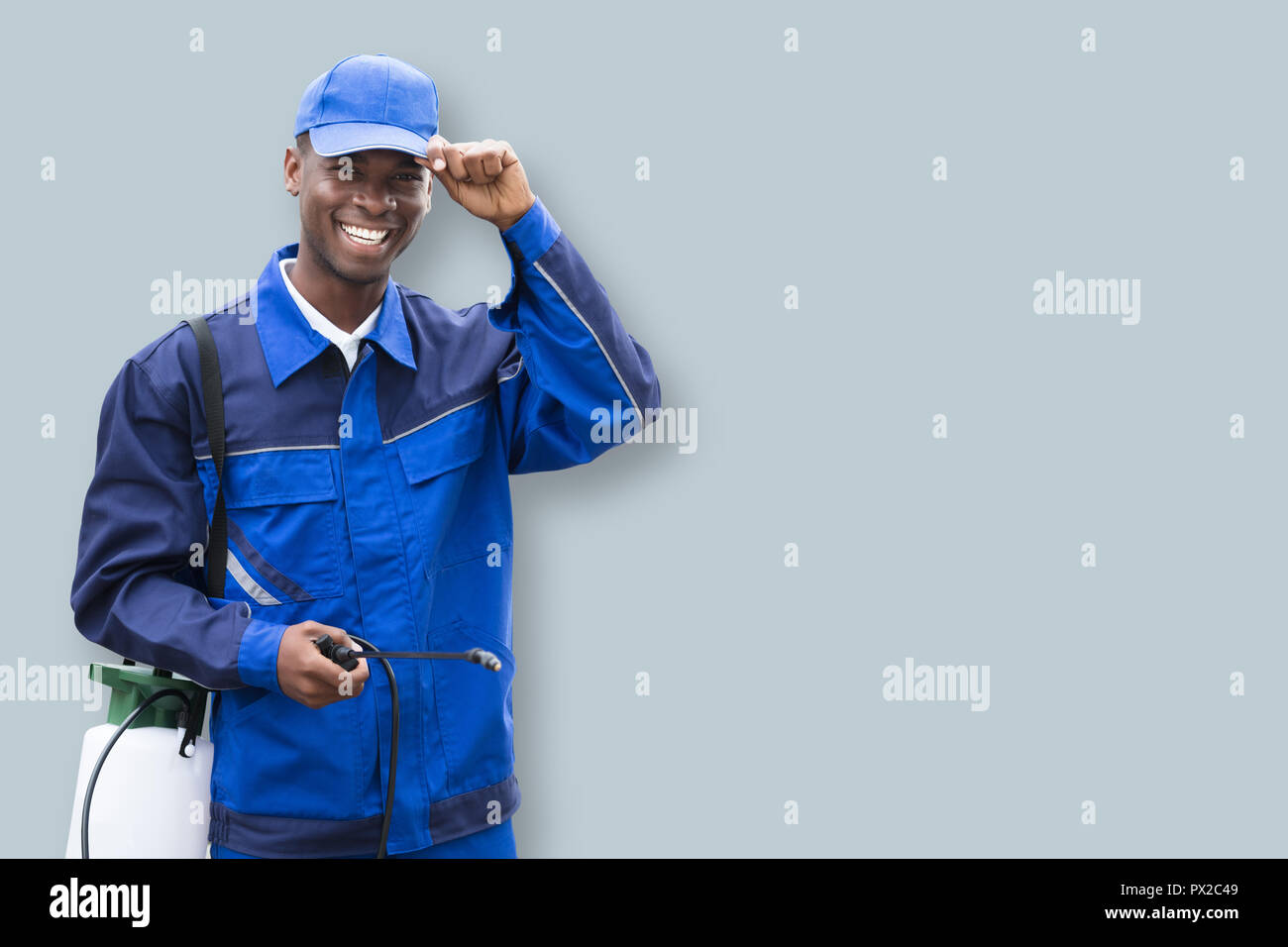 Portrait Of A African Male Pest Control Worker With Pesticide Sprayer Stock Photo