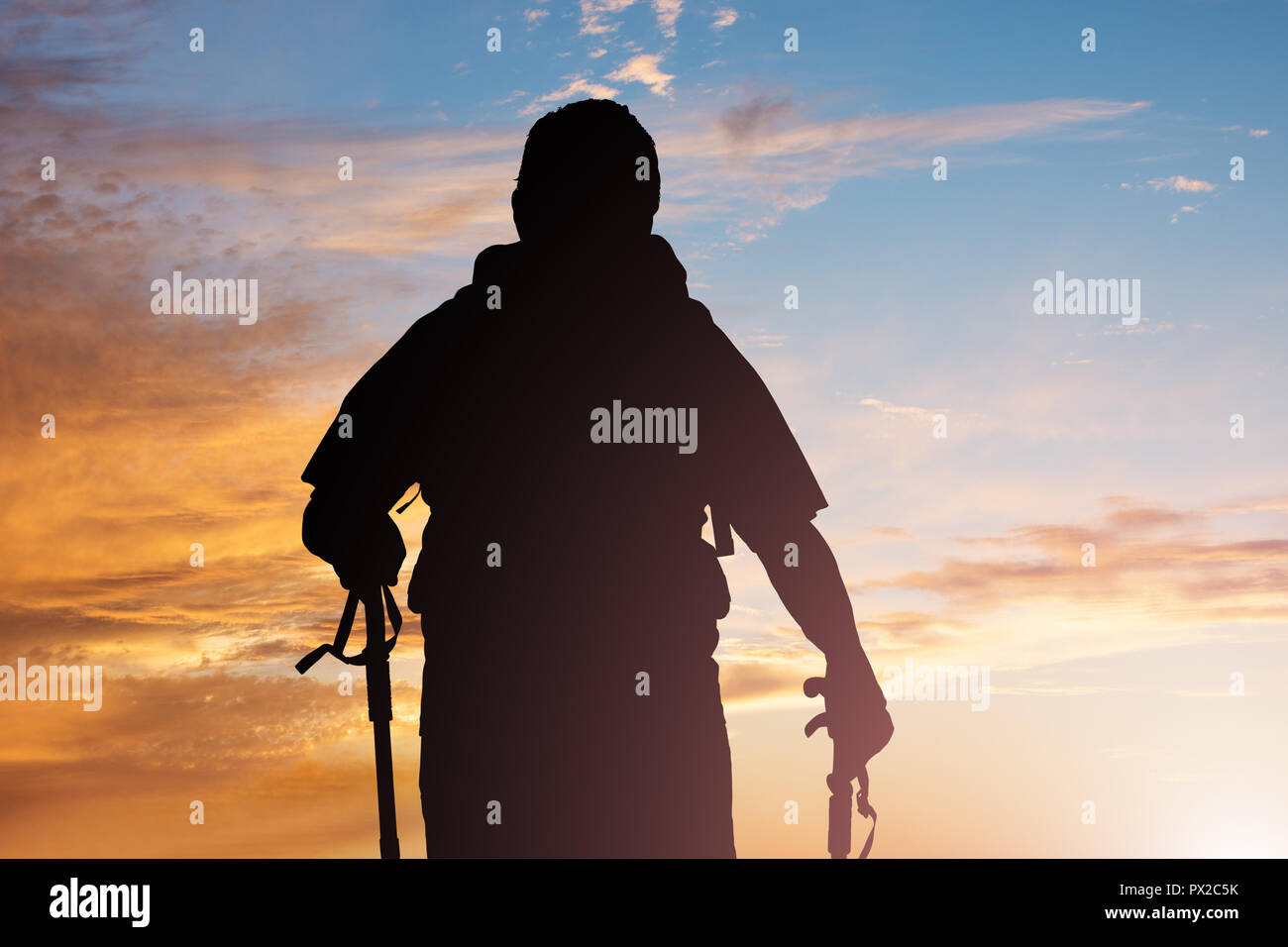 Silhouette Of A Male Hiker With Hiking Pole At Sunset Stock Photo