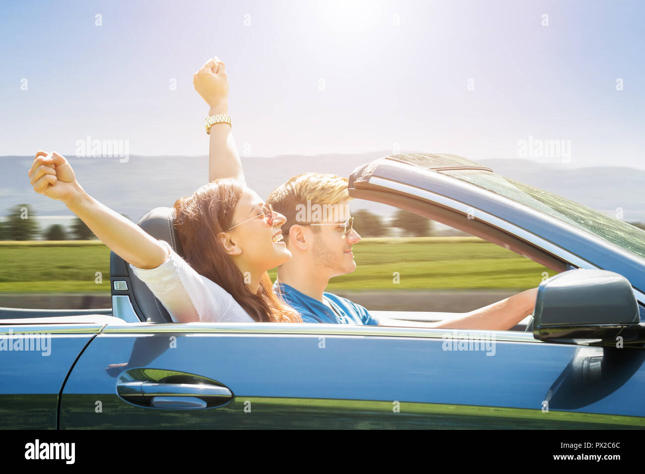 Young Couple Wearing Sunglasses Traveling In The Car Stock Photo