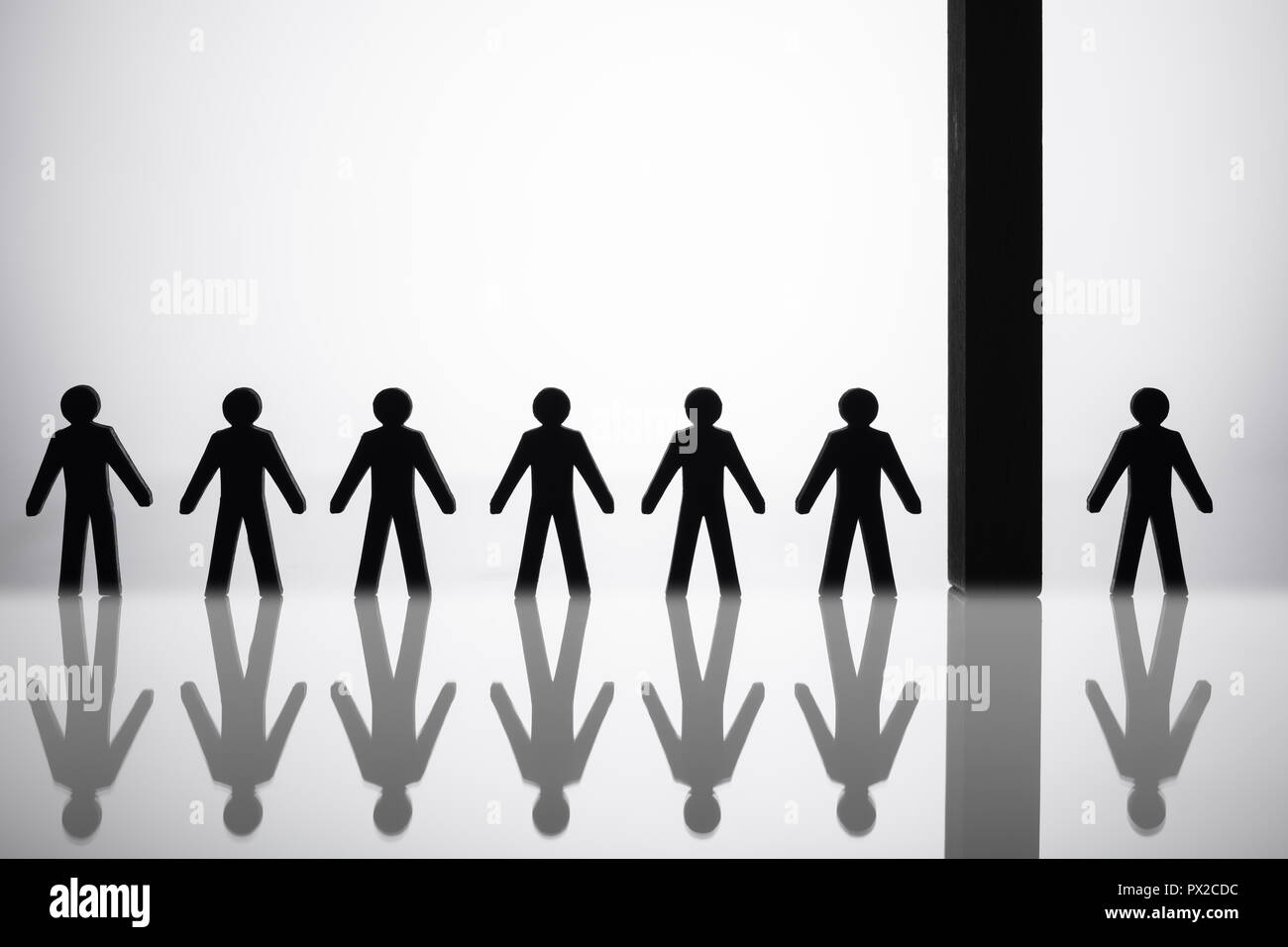 Human Figure Separated By Block From Others Standing In A Row Stock Photo