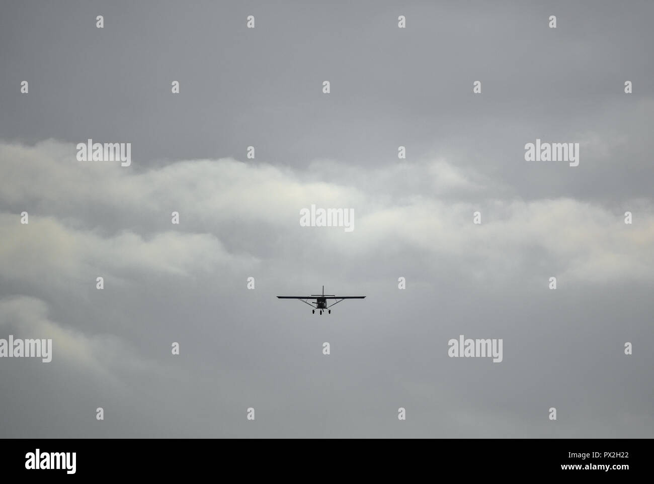 Light aircraft flying over cloudy sky background Stock Photo - Alamy