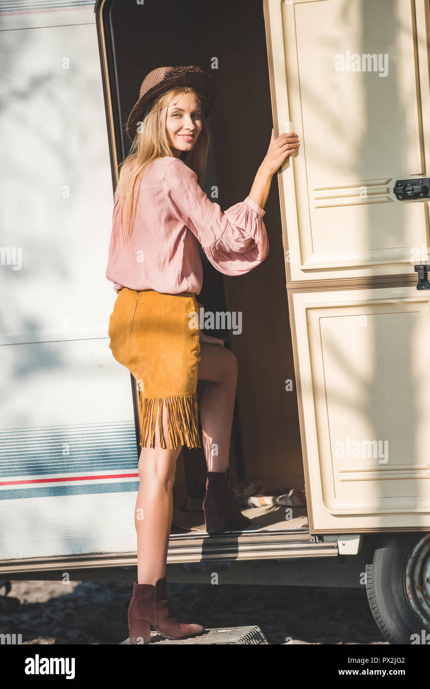 beautiful hippie girl in hat coming into campervan Stock Photo
