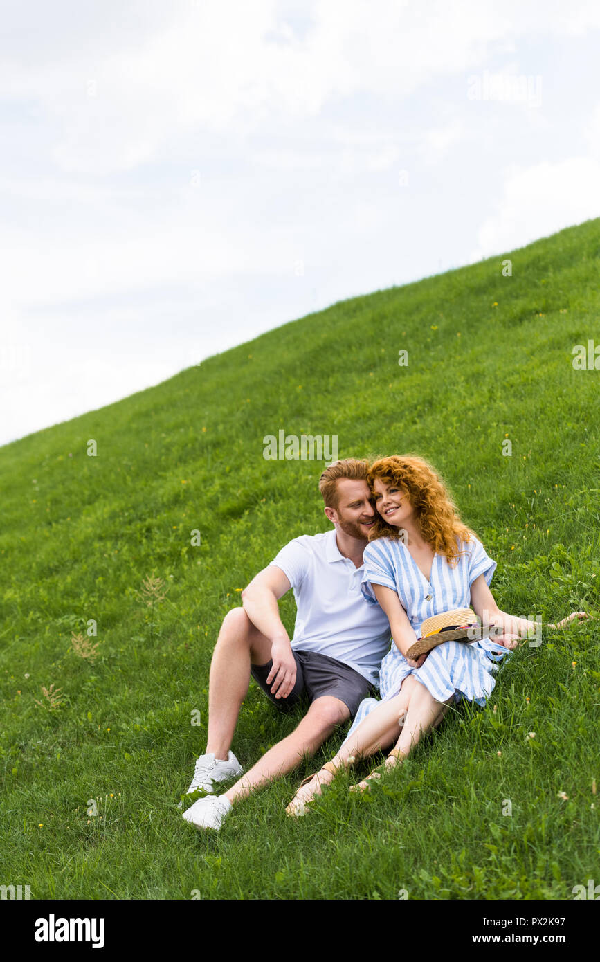 happy redhead couple sitting on grassy hill Stock Photo - Alamy