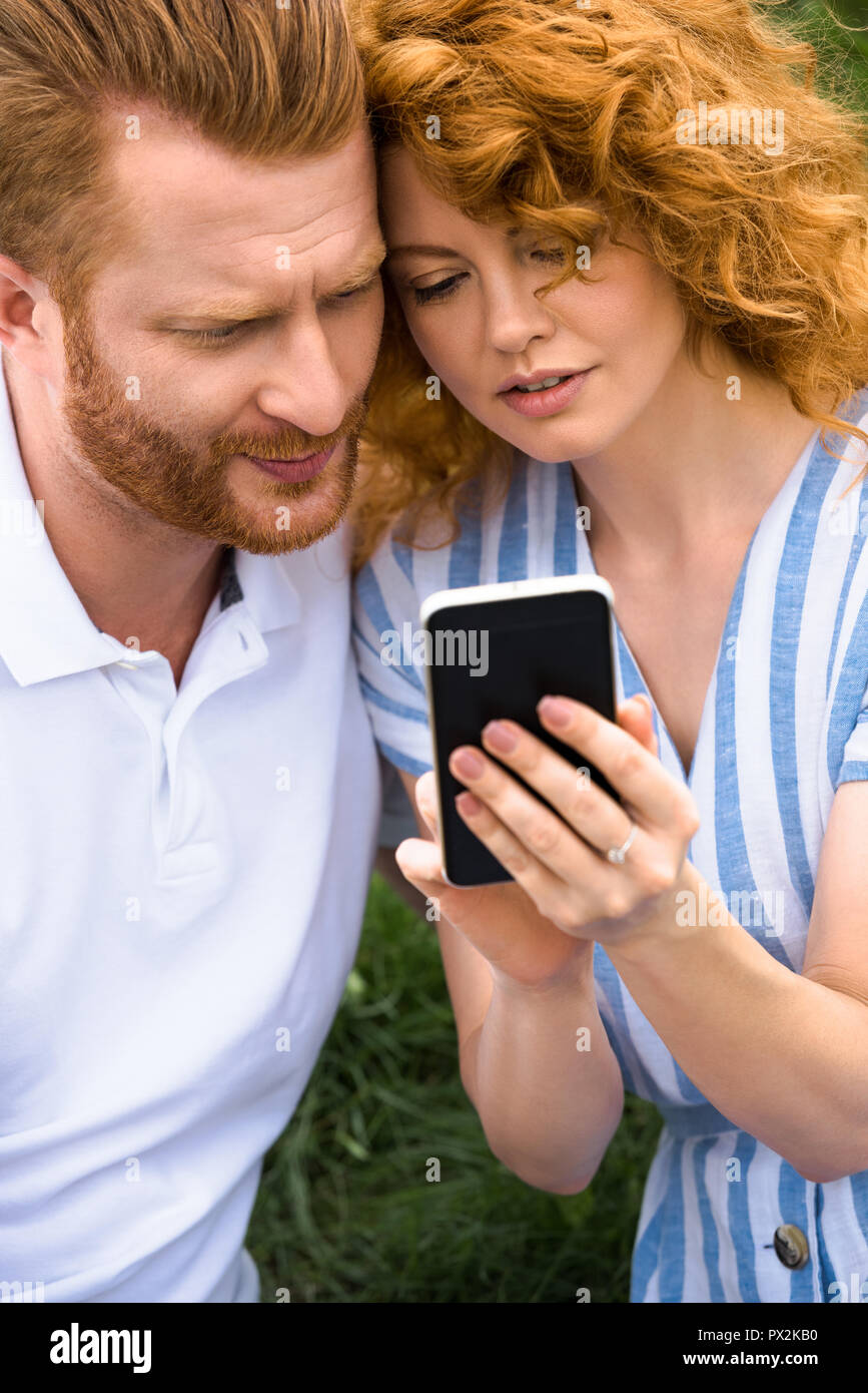 redhead-woman-showing-smartphone-to-boyfriend-outdoors-stock-photo-alamy