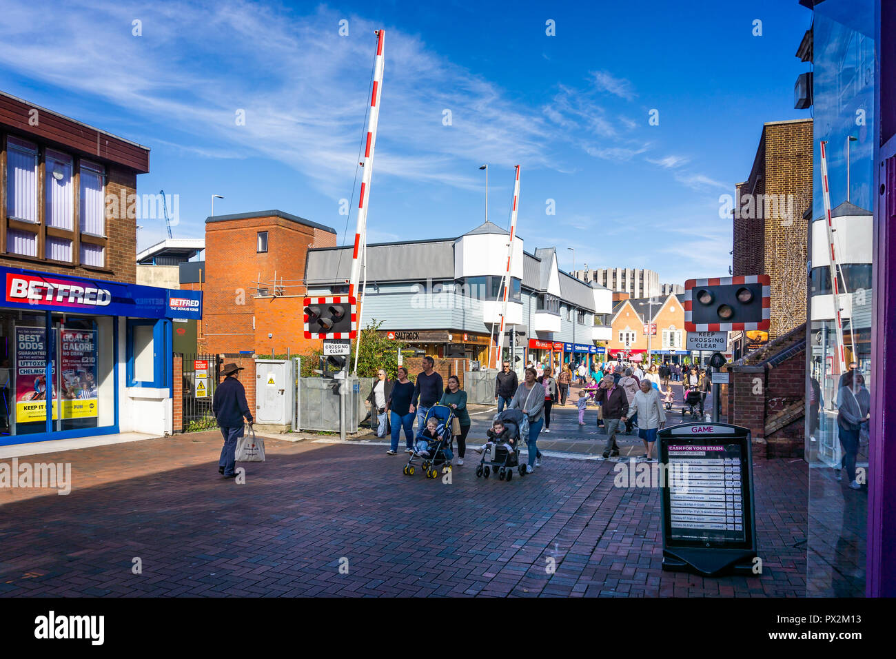 Railway crossing in town centre with safety gates up to allow pedestrians to cross in Poole, Dorset, UK on 18 Ocotber 2018 Stock Photo