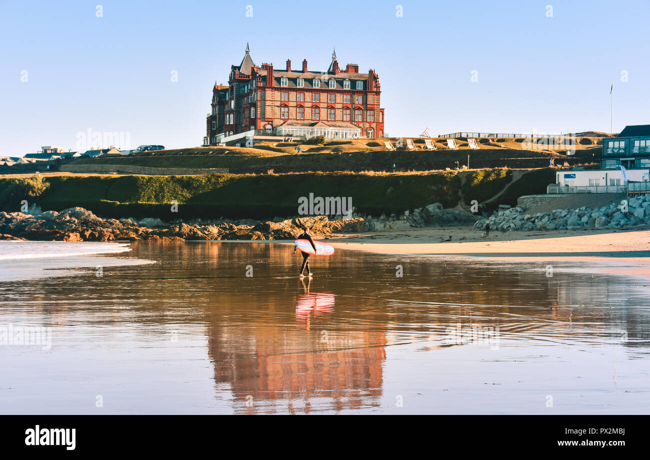 Headland Hotel on Fistral Beach, Newquay, Cornwall with male surfer walking across the beach Stock Photo