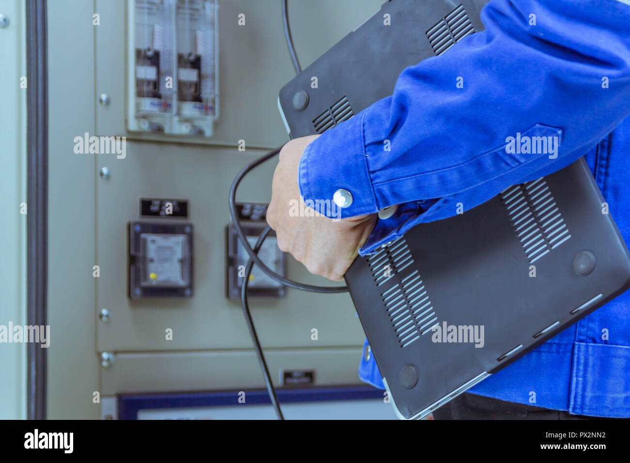 Male engineers are checking the electrical system by program in laptop. Stock Photo