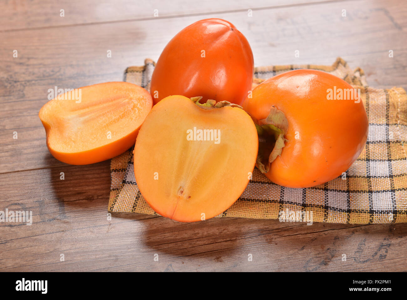 kaki fruits on wooden background Stock Photo