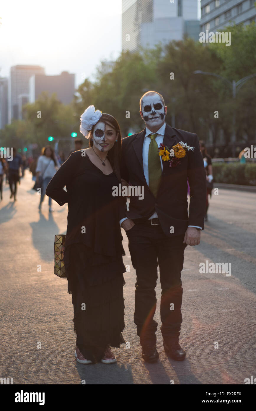 A couple, wearing typical skull makeup and dressed in fashion for the Day of the Dead pose at Mexico's City traditional Day of the Dead parade Stock Photo