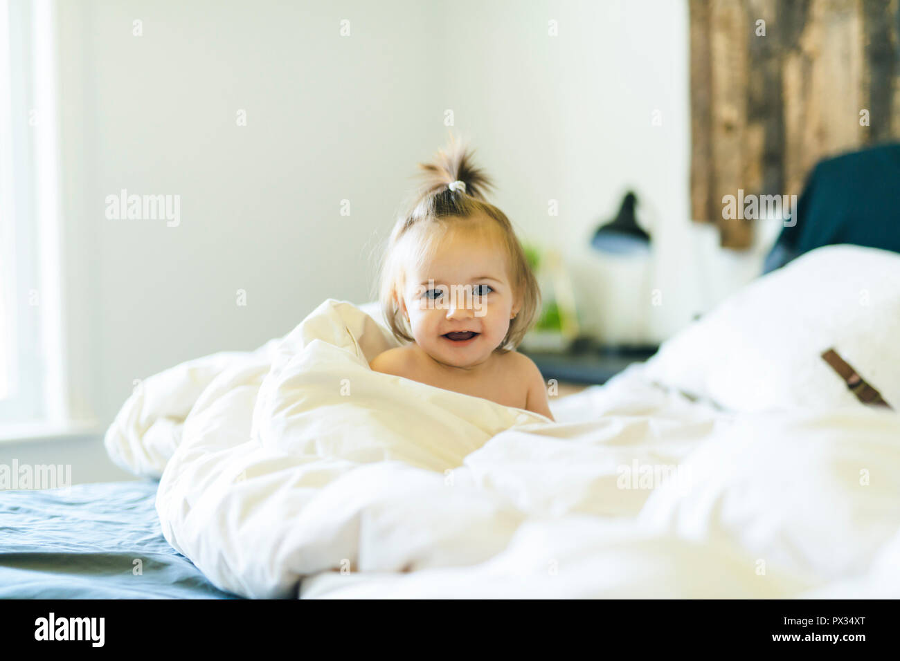 Cute little baby girl on bed at home Stock Photo - Alamy