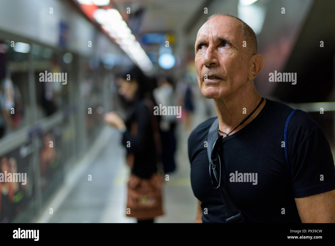 Bald senior tourist man thinking while waiting inside the underg Stock Photo