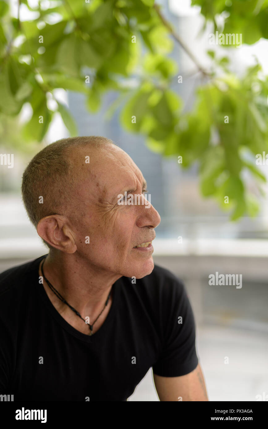 Profile view of bald senior tourist man thinking and relaxing un Stock Photo
