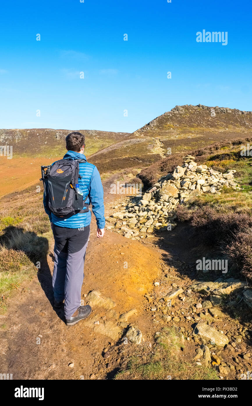 Man in his twenties walking the path from Edale to Ringing Roger on Kinder Scout, Peak District National Park, UK Stock Photo