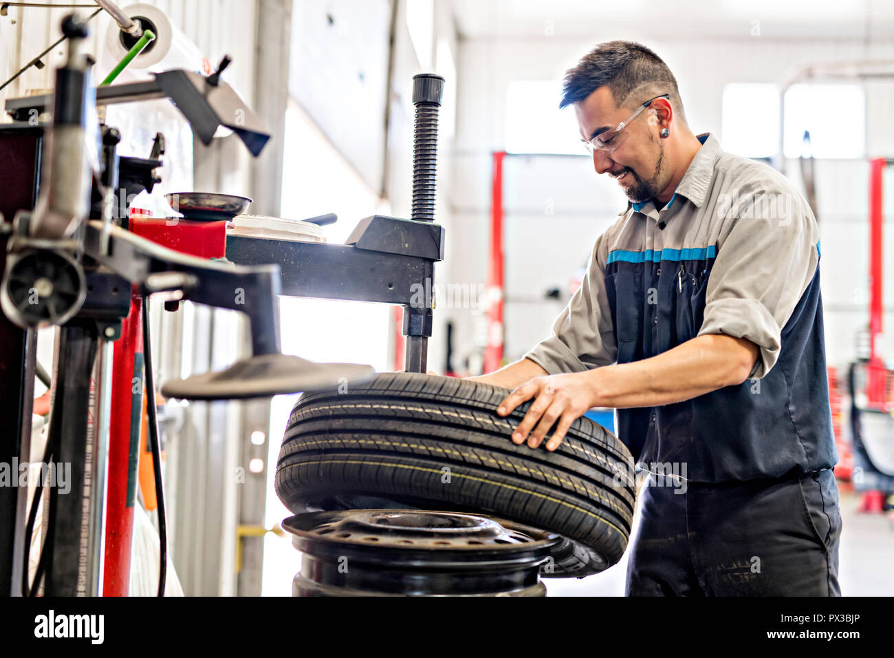 Mechanic changing car tire at work Stock Photo Alamy