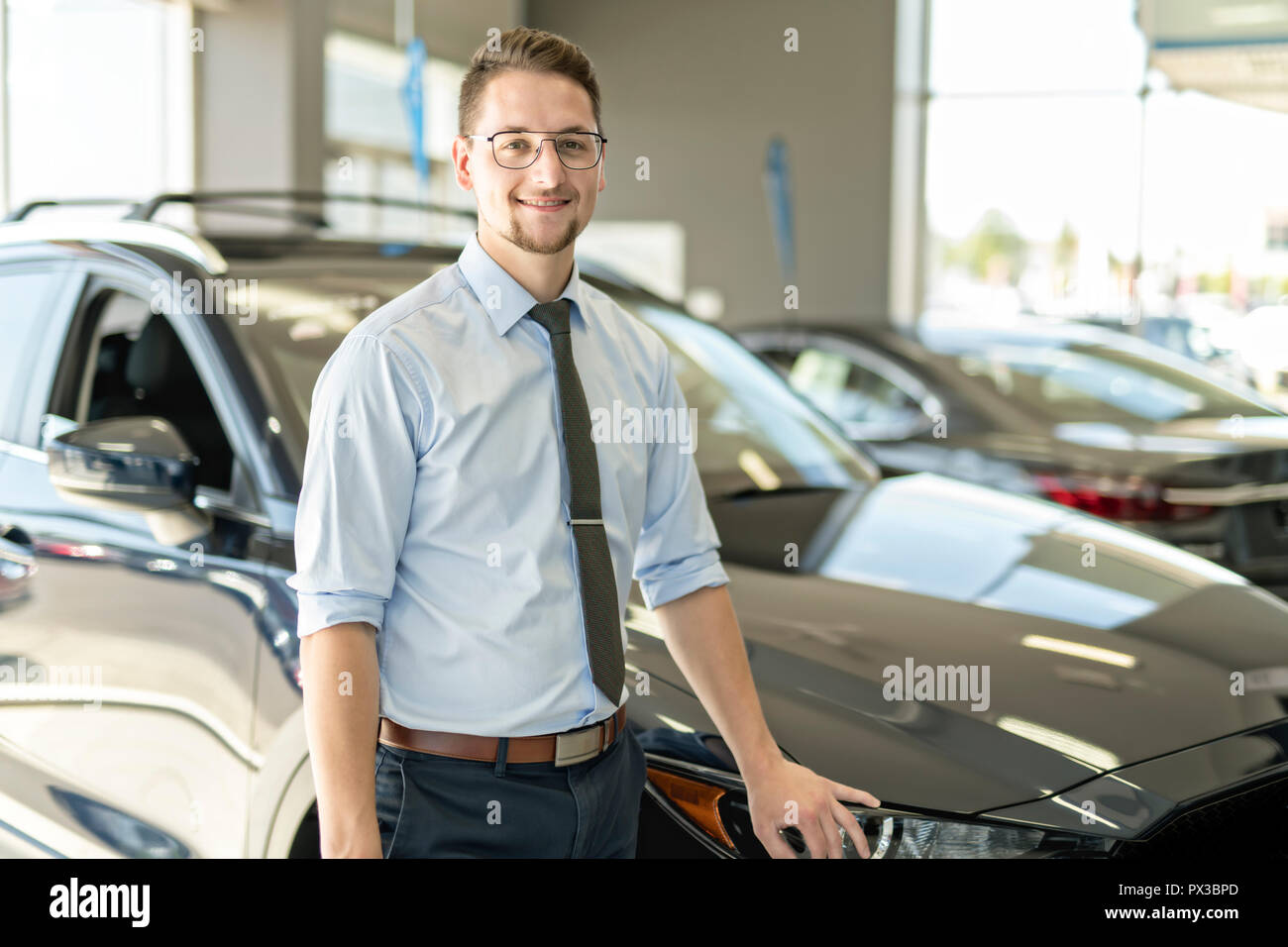 Business man working at a car dealer smiling Stock Photo Alamy