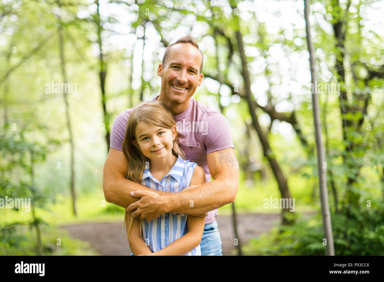 Father having fun in forest with his daughter Stock Photo - Alamy