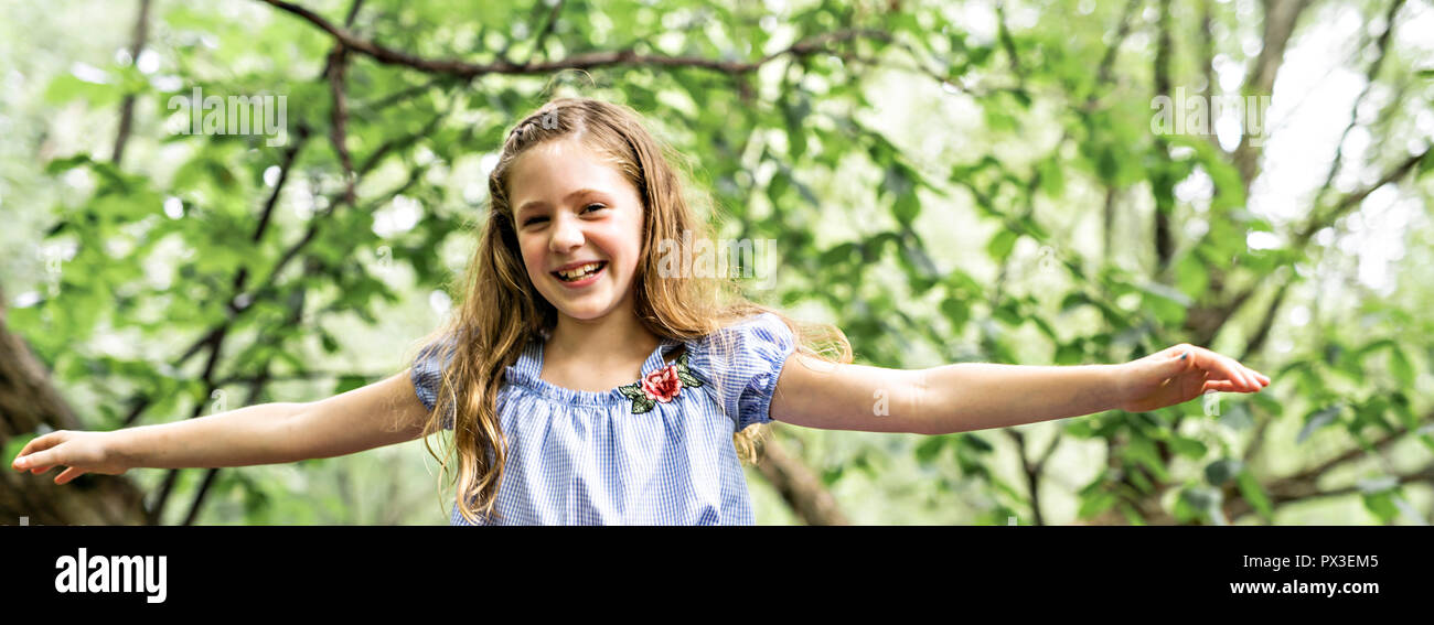 Portrait of a happy young girl outdoors forest balanced Stock Photo - Alamy