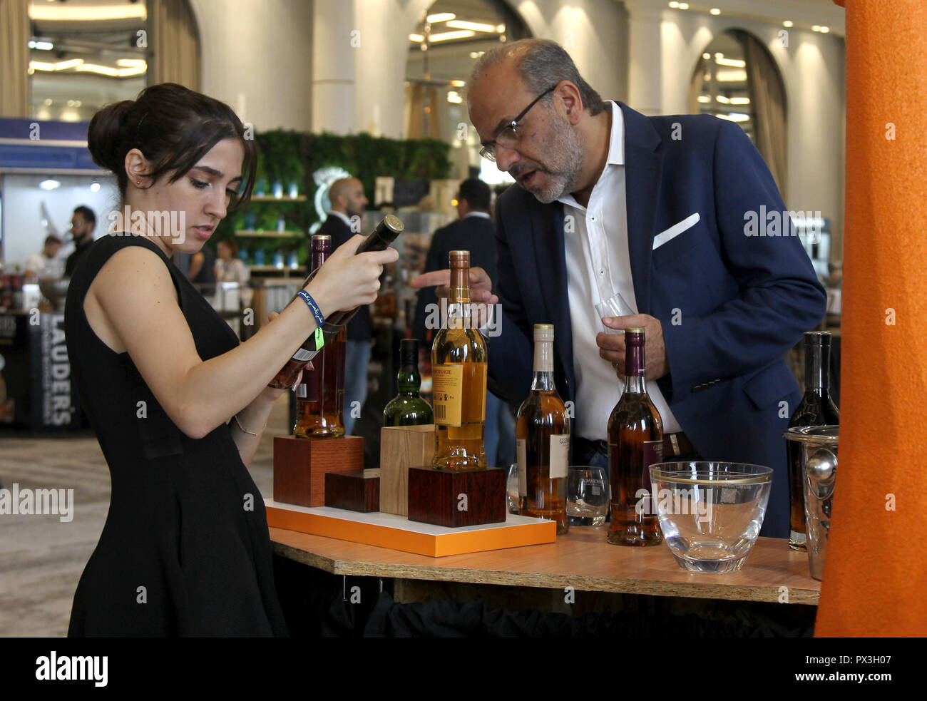 Beirut, Lebanon. 18th Oct, 2018. A visitor talks to a worker during the 3rd edition of Whisky Live Beirut, in Beirut, Lebanon, on Oct. 18, 2018. The 3rd edition of Whisky Live Beirut opened on Thursday. More than 60 international whisky brands display their products to the public during the three-day event. Credit: Bilal Jawich/Xinhua/Alamy Live News Stock Photo