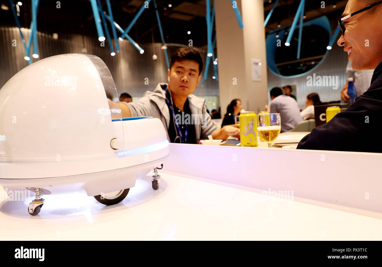 Shanghai. 15th Oct, 2018. A customer takes food served by an AGV (automated guided vehicle) robot in a smart restaurant operated by Chinese e-commerce giant Alibaba at the National Exhibition and Convention Center in east China's Shanghai, Oct. 15, 2018. Credit: Fang Zhe/Xinhua/Alamy Live News Stock Photo