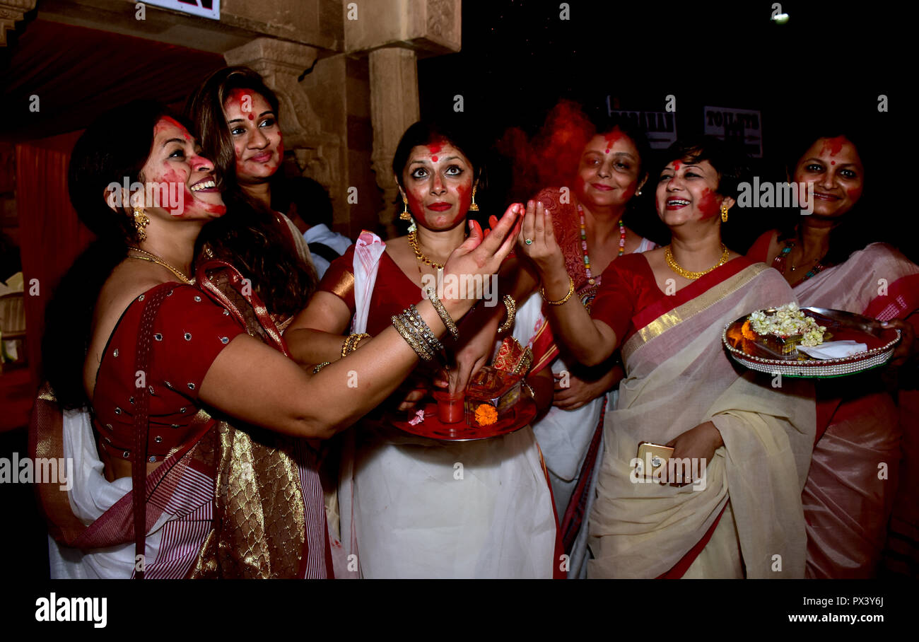 Women seen smearing one another with Sindur during the Sindur Khela. Married women of Bengali community smear one another with Sindur and pray for long and happy married lives in Mumbai during the traditional 'Sindur Khela'. Stock Photo