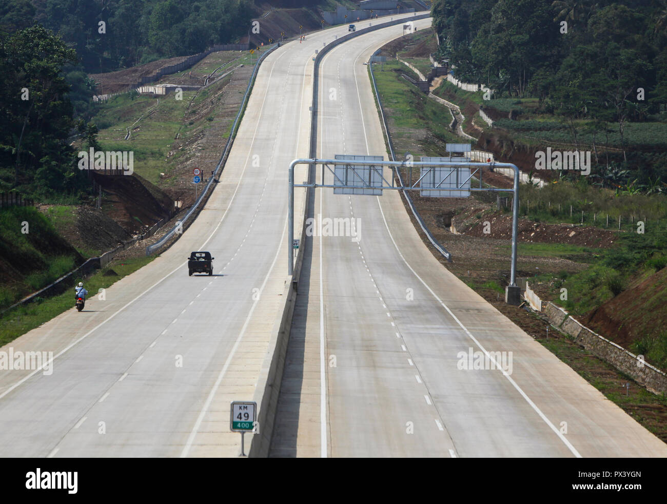 Vehicles pass on section I of Bogor-Ciawi-Sukabumi (Bocimi) Toll Road which is not yet operational. The section I of Bogor-Ciawi-Sukabumi (Bocimi) section I which connects Ciawi to Cigombong along 15.35 kilometers (km) will soon be operational this month. This 54 km toll road has a long history, from stalling, to mutually investor since 1997. Stock Photo