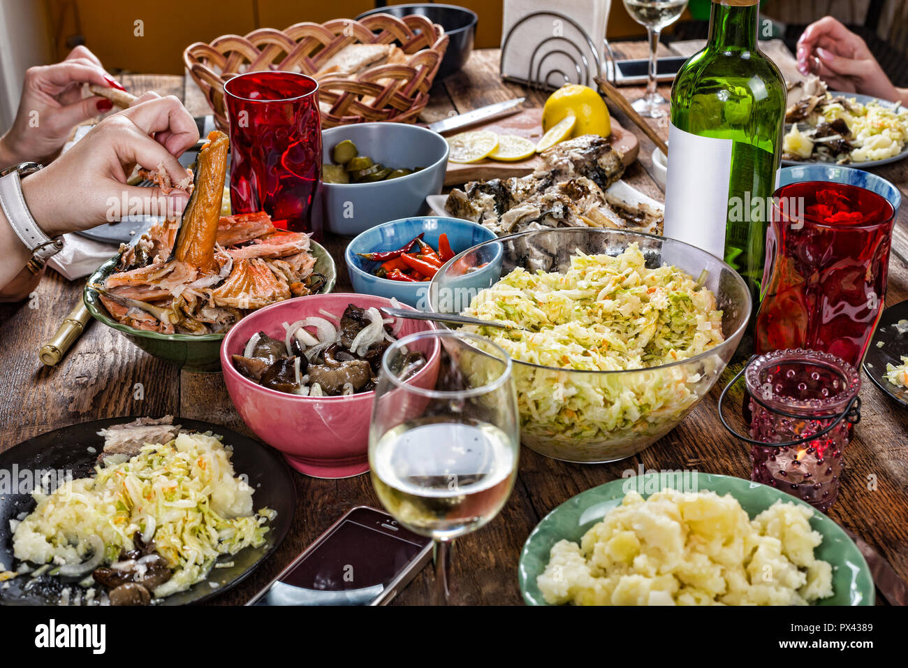 Family dinner variety of Italian dishes with glass of white wine on wooden  table. Happy company having lunch, taking salad dish. Close up, dinner tabl  Stock Photo - Alamy