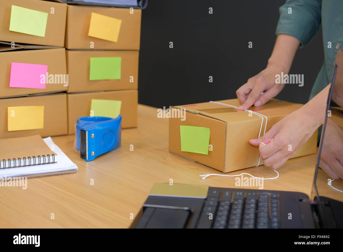 startup small business owner packing cardboard box at workplace