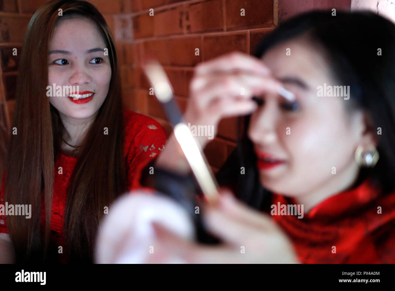 Vietnamese girls with  traditional long dress Ao Dai doing makeup.  Ho Chi Minh City. Vietnam. Stock Photo