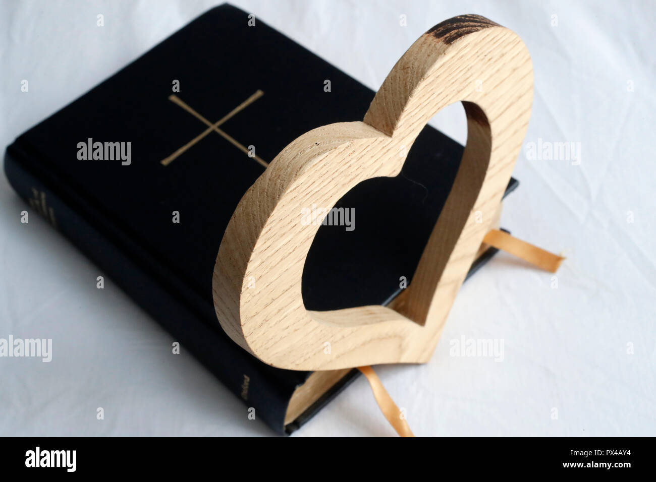 Carved wood heart on a  Bible. Stock Photo